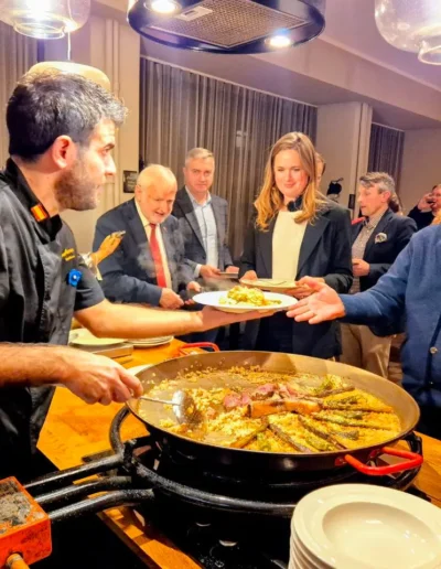 Chef serving paella to guests during a private “De Tú a Tú” event in Tallinn